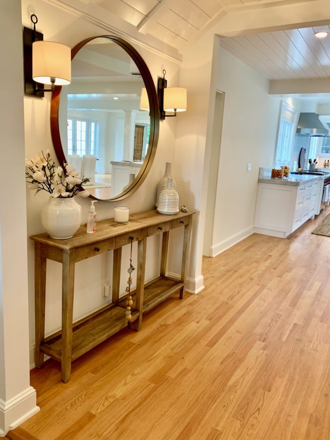 Entrance way with a large round over mirror and slim table.