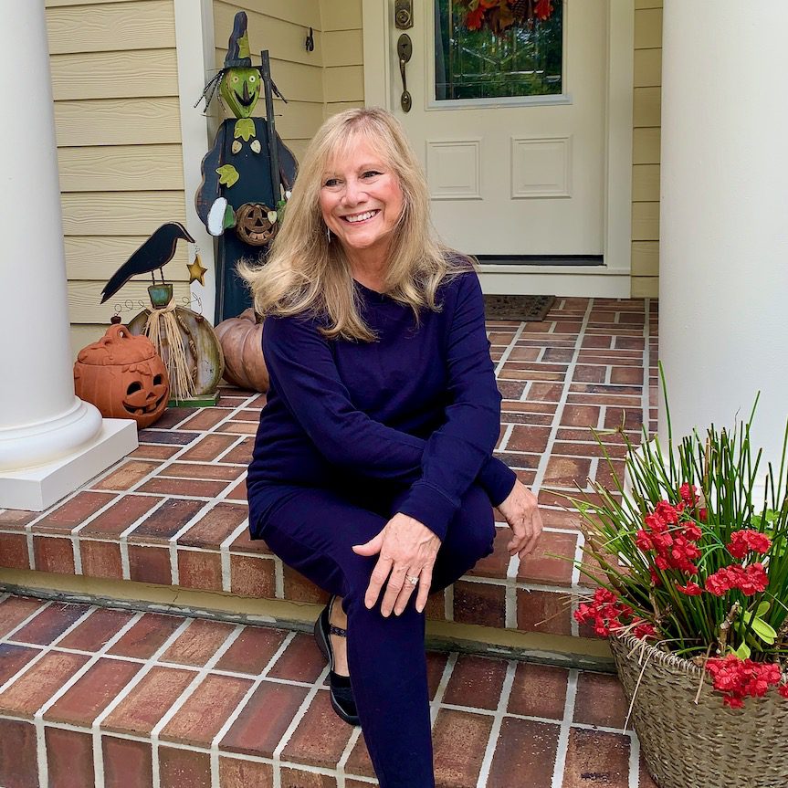 woman wearing a blue sweatsuit sitting on a front porch