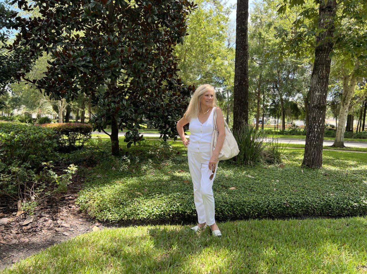 Woman standing under the trees dressed in all white