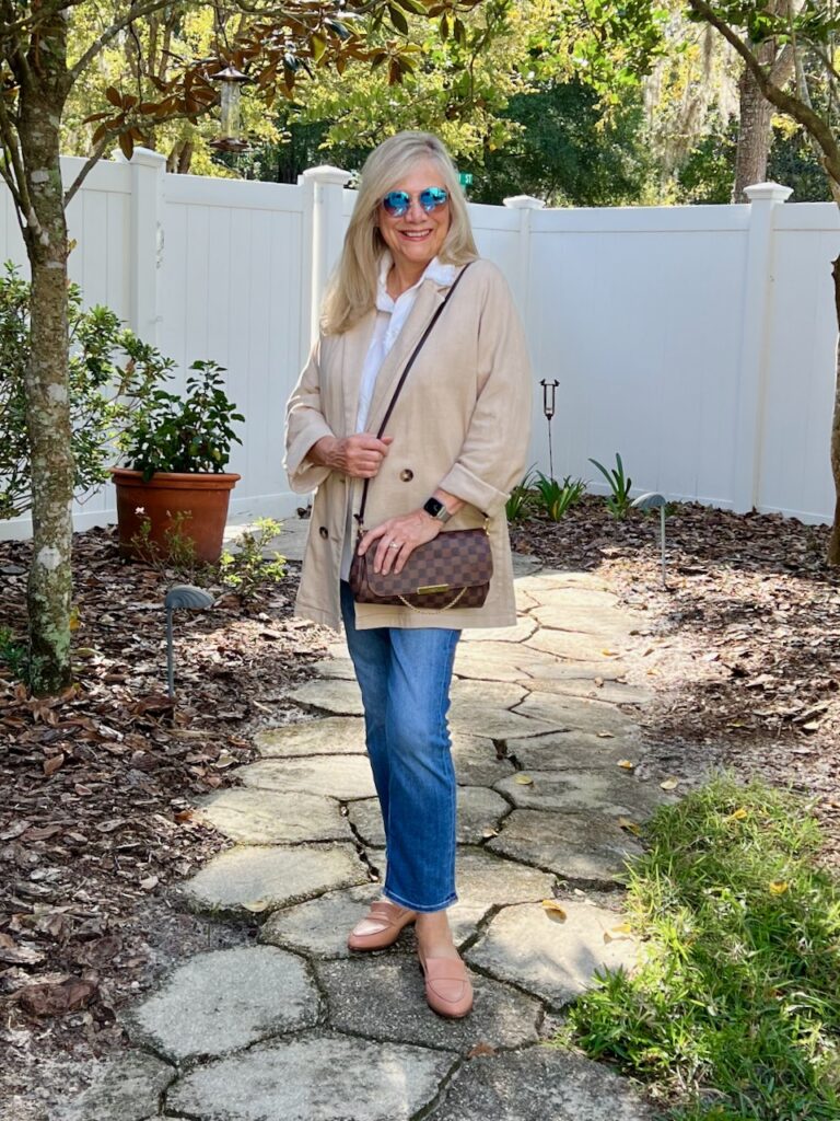 How to Layer Fall Fashion in Florida? Wear a linen blazer. A blonde woman dressed in jeans, a white shirt, and a tan linen blazer.