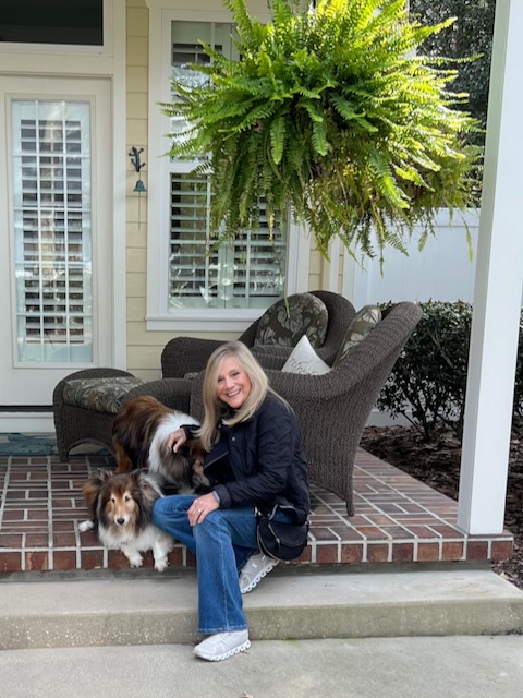 A blonde woman is sitting on the steps of a back porch with a Sheltie dog. Blog Post; Rock Your Jeans In January.