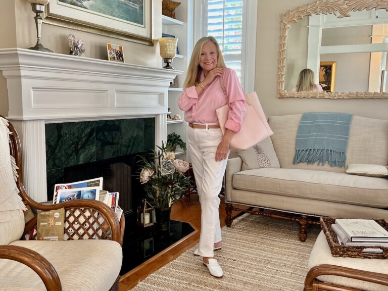 A blonde woman is standing in a living room.