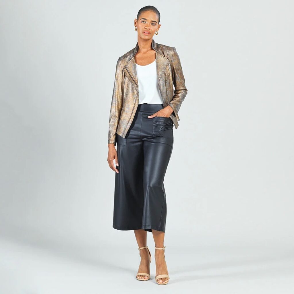 The model wears gaucho pants, a white tee, and a shimmery jacket.