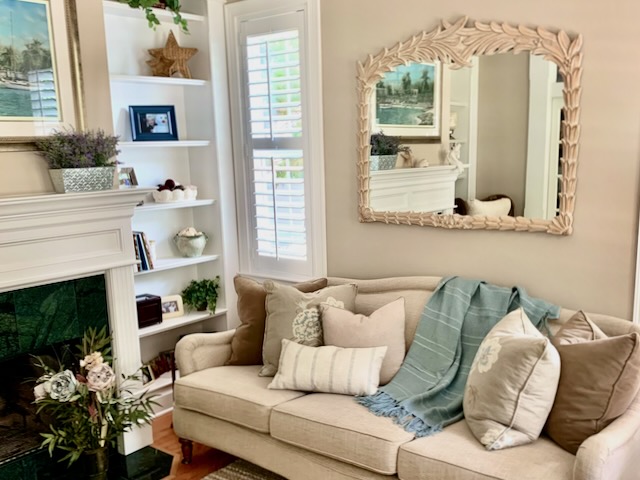 Stylish Southern Living Room, featuring muted tones and a carved mirror over the sofa.