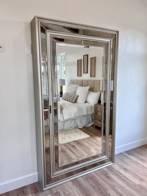 A floor-length mirror trimmed in silver. It doubles as a hidden jewelry cabinet.