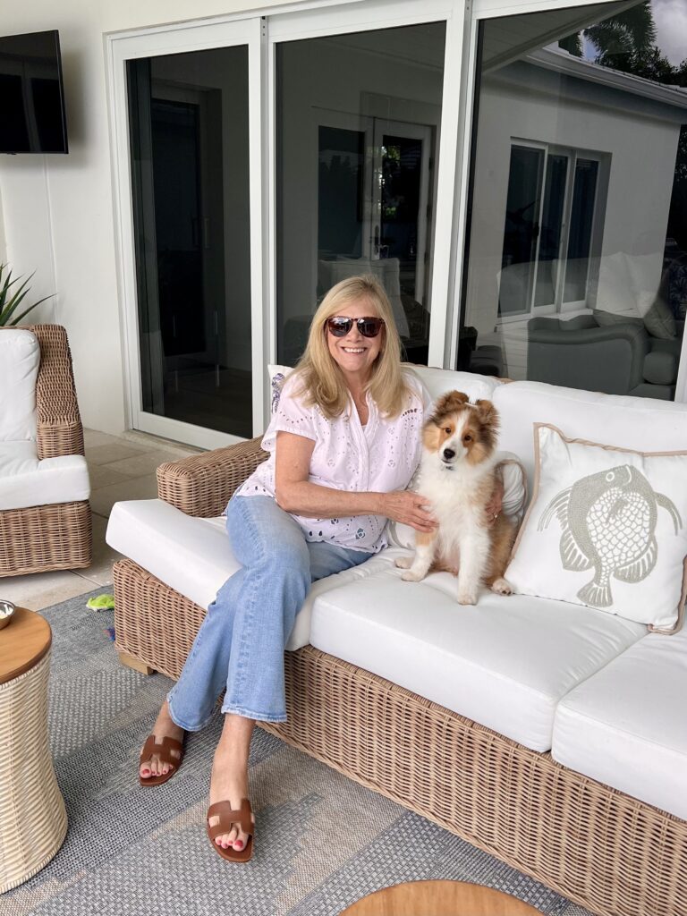 Woman and Sheltie puppy are sitting on the back porch in the Florida sunshine.