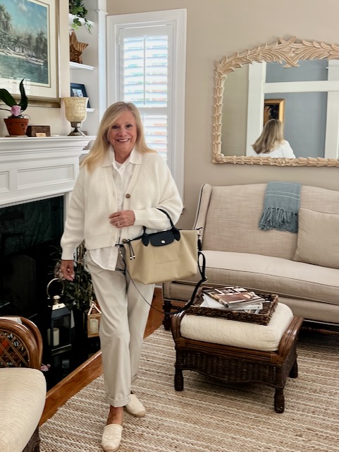 Blonde woman staning in front of the fireplace in a living room