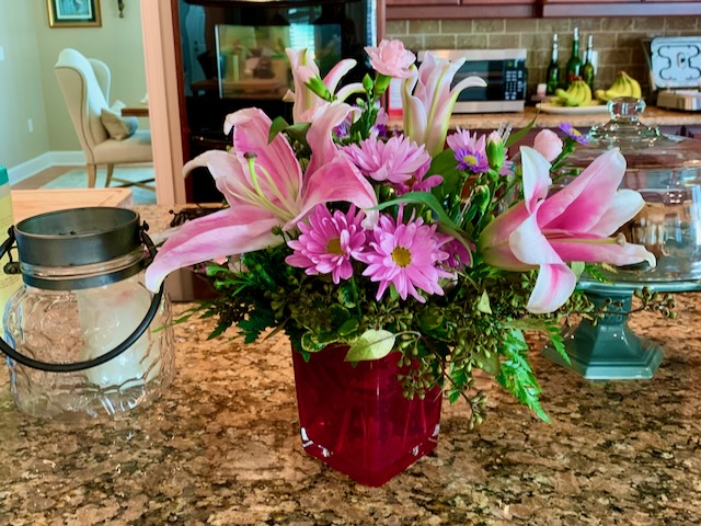 Bright pink and red floral arrangement on the kitchen island.
